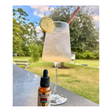 Buzz Drops bottle beside a sparkling lemon mocktail outdoors