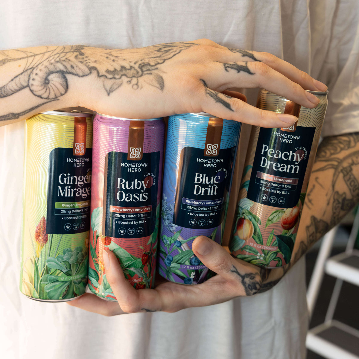 Hands holding Hometown Hero THC lemonade cans