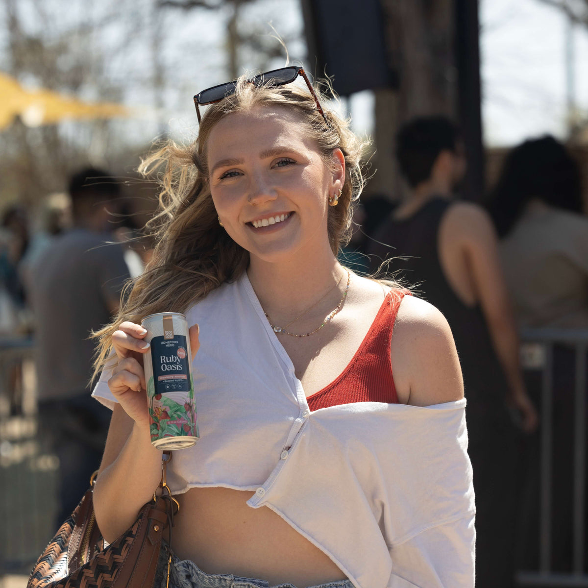 Woman holding a can of Hometown Hero Ruby Oasis THC lemonade